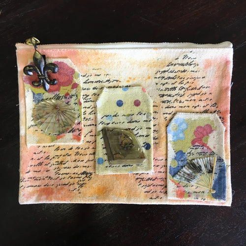 Watercolored canvas zip pouch with tissue paper embellishments.