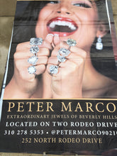 A vinyl billboard for Peter Marco in Beverly Hills featuring a woman with diamond rings on every finger. 