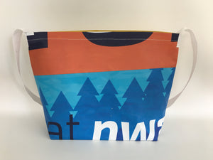 Billboard vinyl tote bag with blue and orange patterns.