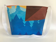 Billboard vinyl tote bag with blue, red and yellow patterns.