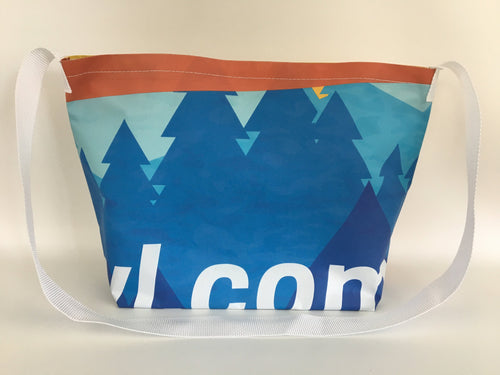 Billboard vinyl tote bag with a pattern of blue evergreen trees.